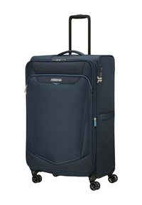 Valigia in tessuto blu con design rigido, manico retrattile, quattro ruote e chiusura con zip. Presenta una tasca laterale e un accento con logo.