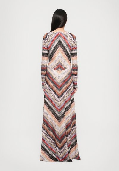 Ilgais rankovėmis maxi suknelė su daugiapalviu zigzagu raštu oranžinės, juodos, pilkos ir kreminės spalvų atspalviais tekstūruotame audinyje.