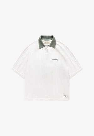 Polo blanc à manches courtes avec des rayures verticales texturées, col vert, trois boutons et "Reternity" brodé sur la poitrine gauche.