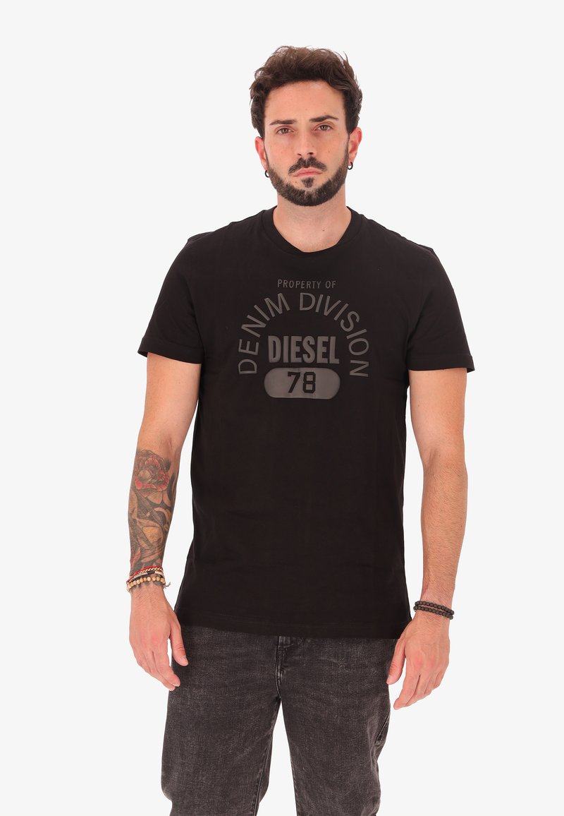T-shirt in cotone nero con scollo rotondo e maniche corte, con una grafica opaca che recita "PROPRIETÀ DELLA DIVISIONE DENIM DIESEL 78."