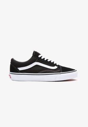 Zapatillas negras de lona con acentos blancos, con punta redonda, diseño con cordones y suela de goma. Logo lateral y detalles de costura visibles.