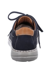 Tmavě modrá kožená bota s hnědým podpatkem, kulatou špičkou a šedou podešví. Obsahuje tkaničky a viditelné švy podél okraje.