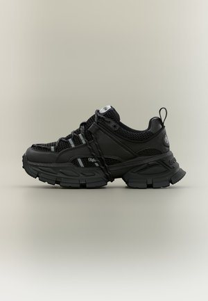 Black chunky sneaker with thick sole, mesh and leather upper, black laces, and branded details on side and heel.