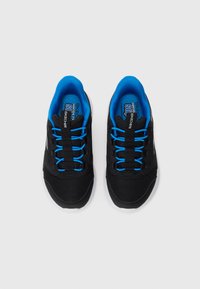 Svart og blå Skechers treningstøvler med mesh-overdel, elastiske lisser og hvite såler sett ovenfra på en hvit bakgrunn.