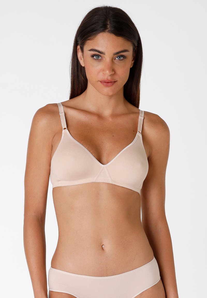 Reggiseno wireless beige con coppe a triangolo, spalline regolabili e una texture di tessuto soffice. Presenta un delicato dettaglio di cucitura lungo i bordi.