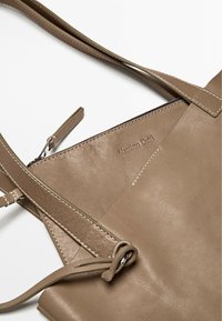 Borsa tote in pelle tan con finitura testurizzata, dotata di manici lunghi e piatti e una tasca con zipper discreta. Logo del marchio impresso all'interno.