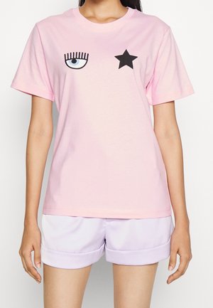 Różowy bawełniany t-shirt z nadrukiem niebieskiego oka i czarnej gwiazdy na przodzie, z krótkimi rękawami i okrągłym dekoltem.