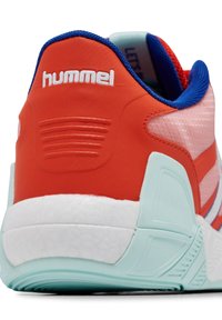 Scarpa sportiva rossa e rosa con tomaia sintetica testurizzata, dettagli blu e suola bianca. Presenta un logo, scanalature e un tallone spesso.