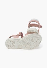 Sandalias de cuero rosas con suelas de goma blanca. Cuentan con correas ajustables y una suela con un patrón de corazones y diseños de ráfaga de sol.