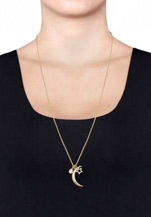 Gold pendant necklace featuring a crescent moon and star design, adorned with a small gemstone, displayed on a black top against a light background.