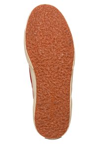 Semelle en caoutchouc avec une surface texturée orange ; parois latérales beiges avec un léger motif ; accents rouges près du talon.