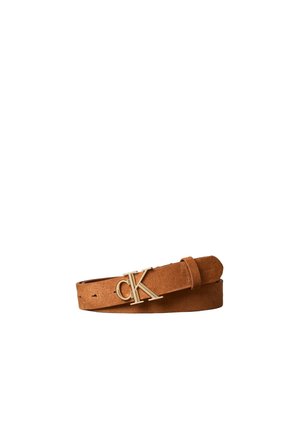 Ceinture en cuir suédé marron avec boucle logo "cK" de couleur dorée, enroulée sur fond blanc.
