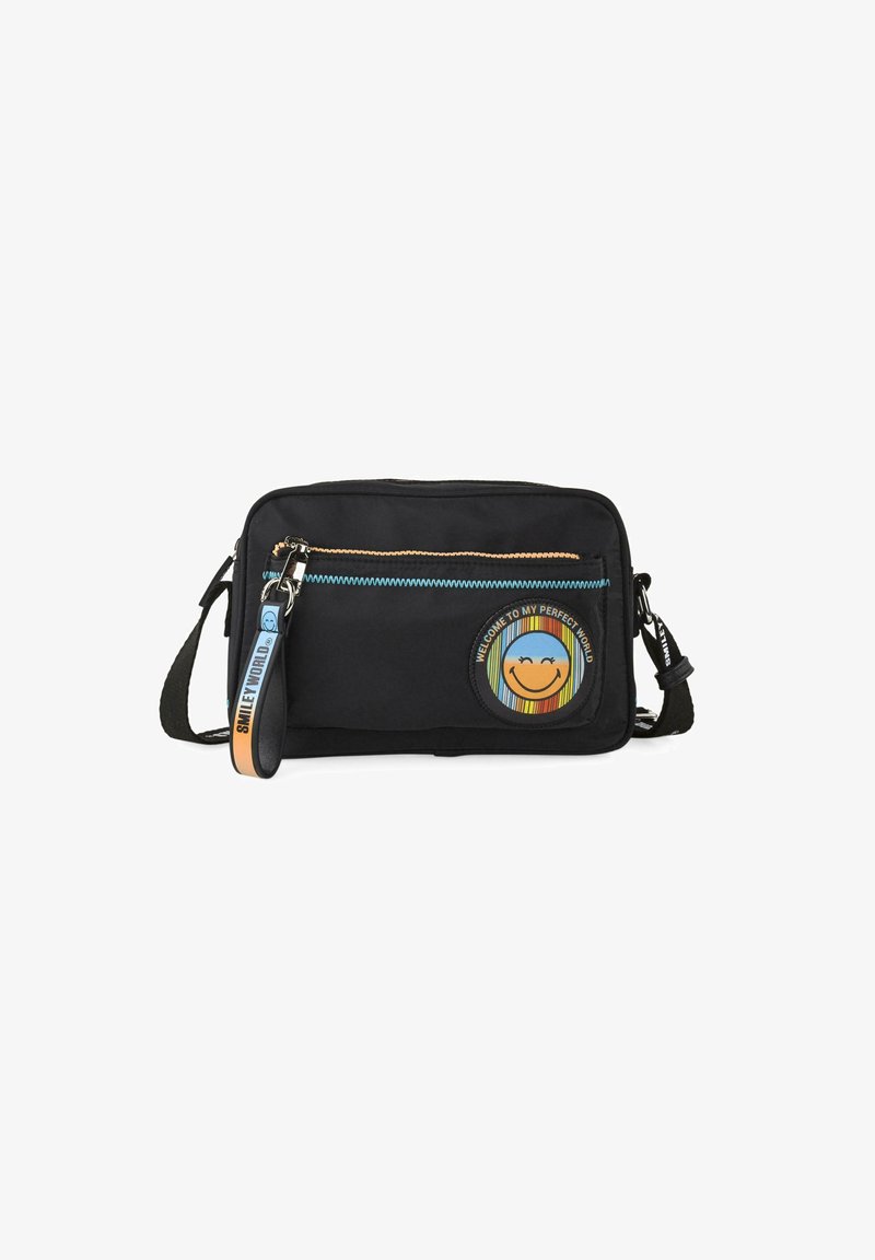 Bolso crossbody de tela negra con un bolsillo con cremallera, parche colorido con una cara sonriente y texto gráfico. Correa de acento con detalle del logotipo.