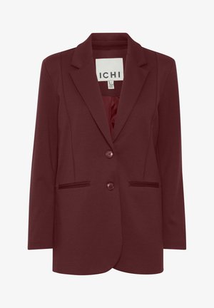 Tumši sarkans bleizeris, izgatavots no mīksta auduma, ar iegrieztu apkakli, divām priekšējām pogām un sānu kabatām ar smalkiem apdariem.