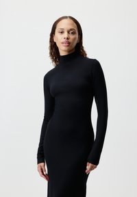 Figurnær svart kjole med høy hals, lange ermer og glatt, elastisk stoff, med et strømlinjeformet, minimalistisk design.