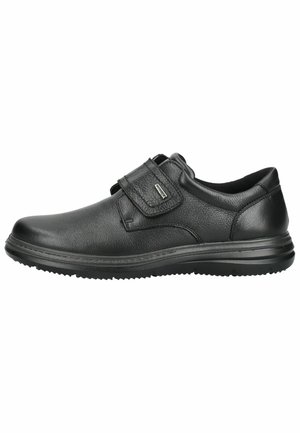 Schwarzer Herrenschuh aus Leder mit Klettverschluss und profilierter Gummisohle, für Komfort und leichtes Anziehen konzipiert.
