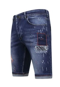 Donkerblauwe denimshorts met versleten details, waaronder rafelige randen en een patch met rode stiksels. Heeft een five-pocket ontwerp.