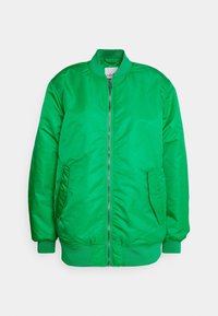 Zelená bomber bunda vyrobená z hladké, vycpávané tkaniny. Má přední zip, dvě boční kapsy a žebrovaný límec a manžety.