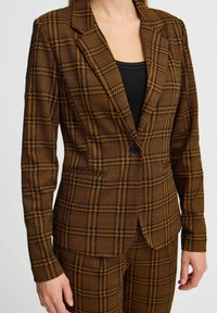 Brown houndstooth blazer with a tailored fit, featuring a notched lapel, single black button closure, and structured shoulders.