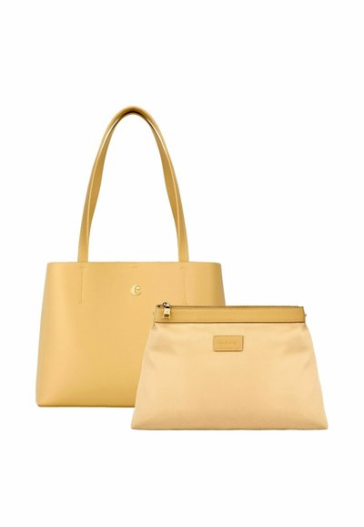 Rumena usnjena torba z dolgimi ročaji in ujemajoča rumena torbica z zadrgo ter usnjenim okrasjem, postavljeni drug ob drugem na belem ozadju.