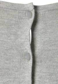 Grau gestrickter Stoff mit einer gerippten Textur, versehen mit zwei Kunststoffknöpfen an der Vorderseite, sichtbaren Nähten entlang der Kanten.