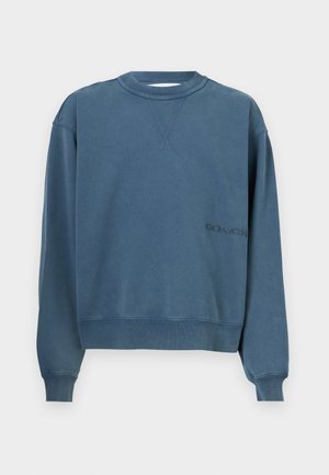 Mėlynas džemperis su apvaliu kaklu, pagamintas iš minkštos medvilnės, su iškiliais rankogaliais ir apatine krašte, priekio su mažai siuvinėtu logotipu.