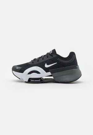 Musta ja valkoinen Nike-juoksukenkä, jossa on näkyvä Air Zoom -pehmustus ja verkkopäällinen, esitetty sivulta valkoista taustaa vasten.
