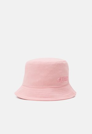 Zachte roze stoffen bucket hat met een subtiel geborduurd "GUESS"-logo aan de zijkant, weergegeven op een effen lichte achtergrond.
