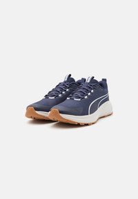 Navy blue athletic shoes with a textured upper, reflective laces, white accents, and a rubber outsole. Features a cushioned sole for support.