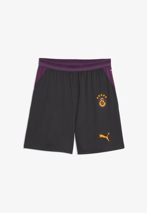 Czarne spodenki sportowe z fioletowym pasem i bocznymi panelami, z żółtym logo Puma i emblematem klubu piłkarskiego Galatasaray z gwiazdami.