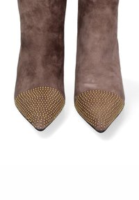 Stivali alla caviglia con punta affusolata in morbido suede grigio, con una punta decorata da borchie dorate a motivo, caratterizzati da una texture liscia e una silhouette slanciata.
