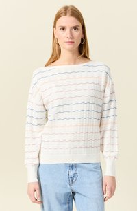 Maglione lavorato a maglia bianco con motivi a onda in arancione, blu e rosa. Presenta un collo a barchetta e polsini a coste, offrendo una vestibilità rilassata.
