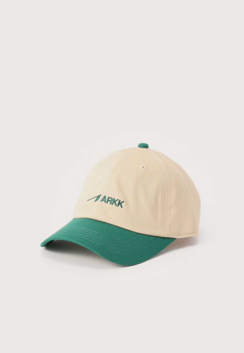 Μπεζ μπέιζμπολ καπέλο με πράσινο καμπυλωτό γείσο και πράσινο κέντημα λογότυπο "ARKK" στην μπροστινή πλευρά.