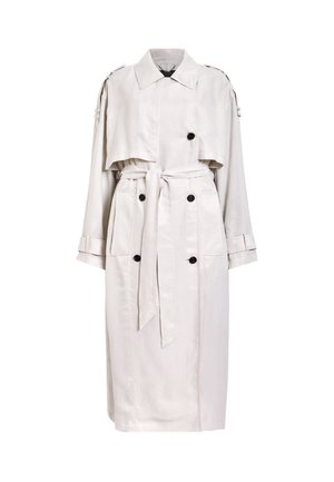 Light beige trench coat with a cropped cape overlay, double-breasted front, two side pockets, and a tie belt at the waist.