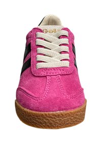 Sneaker in suede rosa con strisce nere, lacci crema e una suola in gomma marrone testurizzata. Presenta una punta rotonda e un logo sulla linguetta.