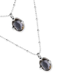 Collar de plata con una cadena texturizada que presenta dos piedras ovaladas y facetadas de color gris, montadas en engastes estilo bisel.
