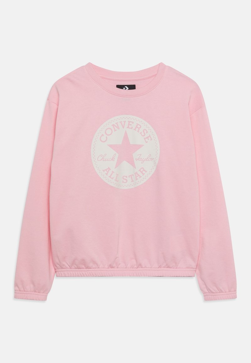 Sweat-shirt rose clair à manches longues avec poignets et ourlet élastiques, avec un logo circulaire Converse All Star blanc délavé sur la poitrine.