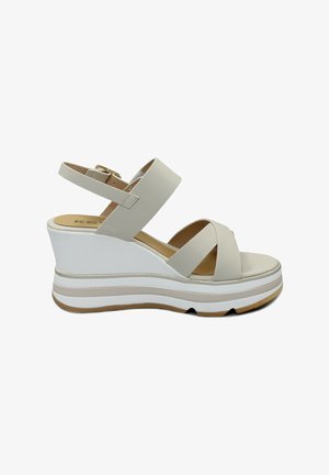 Sandalias de cuña con parte superior sintética en beige, correa para el tobillo ajustable, correas frontales entrelazadas y una suela de plataforma blanca en capas.