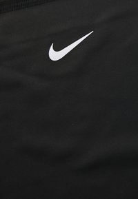 Sort sportsstof med et fremtrædende hvidt Nike swoosh logo. Glat tekstur med en tætsiddende design og ingen yderligere mønstre eller detaljer.