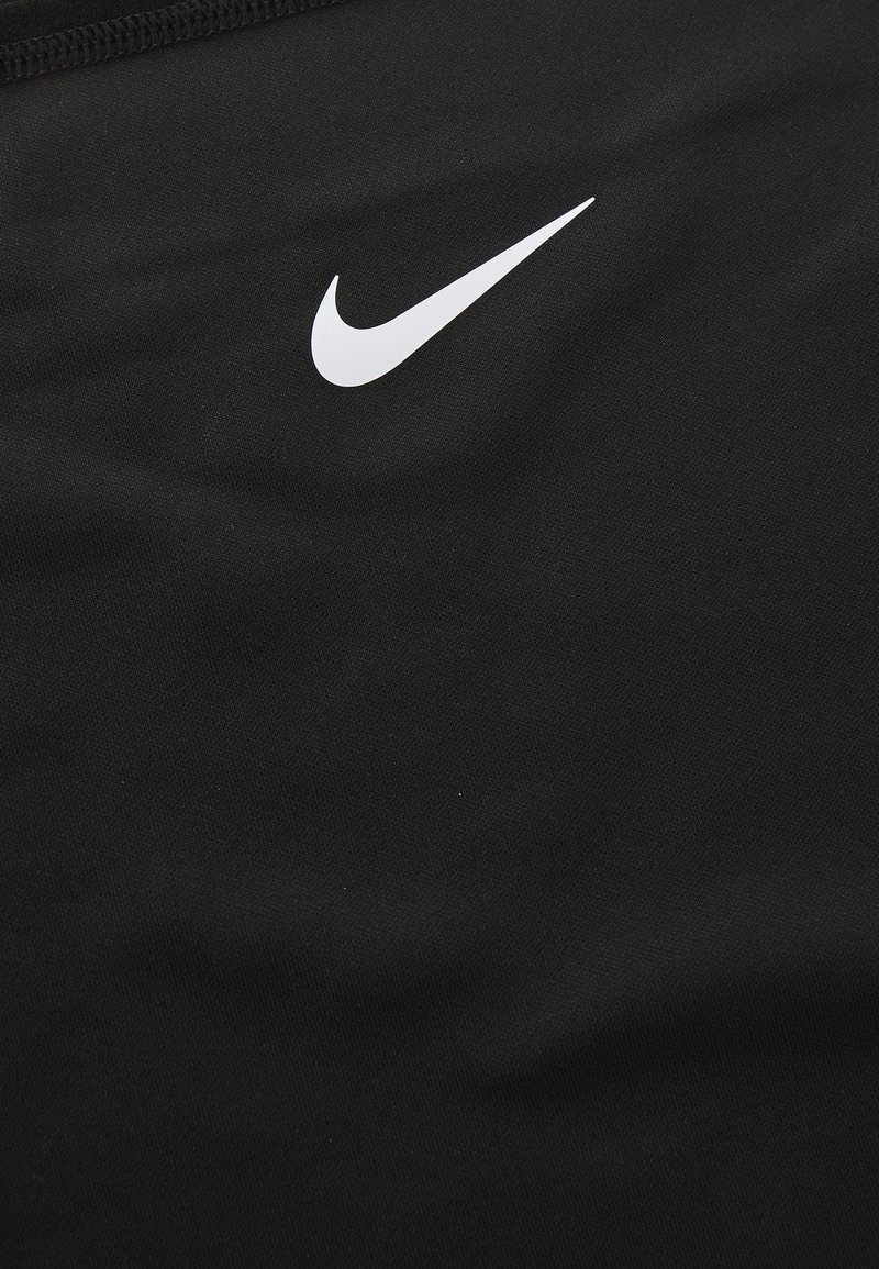 Tissu de sport noir avec un logo swoosh Nike blanc bien en évidence. Texture lisse avec un design ajusté et sans motifs ou accents supplémentaires.