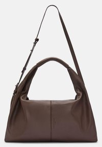 Brązowa skórzana torba na ramię o miękkiej fakturze, luźnym designie, długim pasku i wyraźnym przeszyciu z przodu.