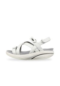 Sandalia de cuero blanco con tiras cruzadas y una correa ajustable en el tobillo, que presenta una plantilla acolchada gris y una suela curva y ligera.