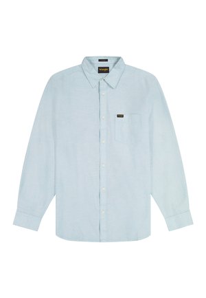 Hellblaues, langärmliges Hemd mit Knöpfen, Kragen und Brusttasche, die einen kleinen Wrangler-Logo-Patch zeigt, flach auf weißem Hintergrund gelegt.