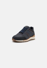 Marineblauwe sneakers met een mix van gestructureerde en gladde materialen, geperforeerde details en bruine accentstrepen op de zijkanten. Gumrubberen zool.