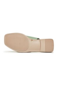 Semelle d'une mule plate avec une semelle extérieure en caoutchouc beige et un maintien au talon, taille 38 marquée sur la semelle, partie supérieure en vert clair visible.
