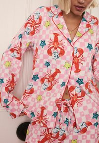 Pinker karierten Schlafanzugset mit einem Muster aus Hummern und Seesternen. Baumwollmaterial mit kontrastierenden roten Paspeln und einer Kordelzug-Taille.