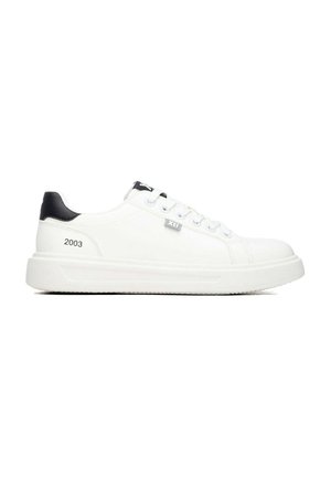 Zapatilla blanca de corte bajo con detalle negro en el talón, cordones en la parte delantera y "2003" impreso en el lateral, vista desde el lado exterior.