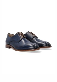 Marine leren schoenen met een gladde afwerking, ronde neus, vijf bruine veterogen en een lichtbruine leren zool.