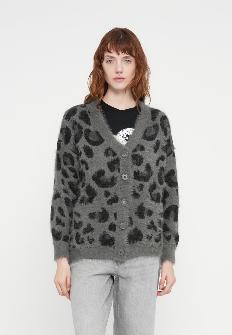 Grå cardigan med svart leopardmønster, med V-hals, fem knappefeste, lange ermer og mykt, teksturert materiale.