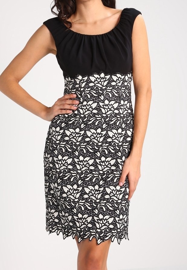 Robe noire sans manches avec un col froncé ; motif floral en dentelle blanche sur la jupe ; détail d'ourlet festonné.